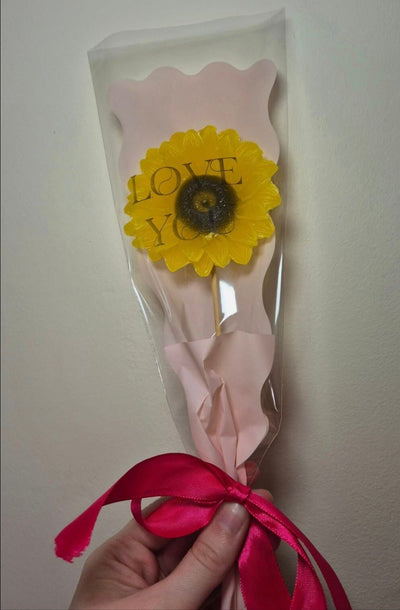 single sunflower wax melt in pink packaging with a pink ribbon around the bottom of the flower 