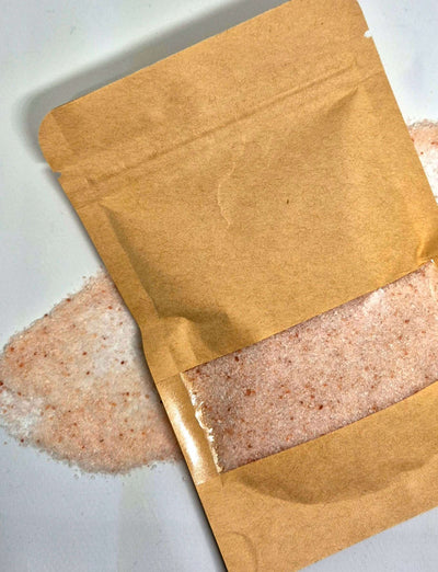 Brown kraft bag of bath salts on a white background, showcasing mineral-rich contents for relaxing bath experience.