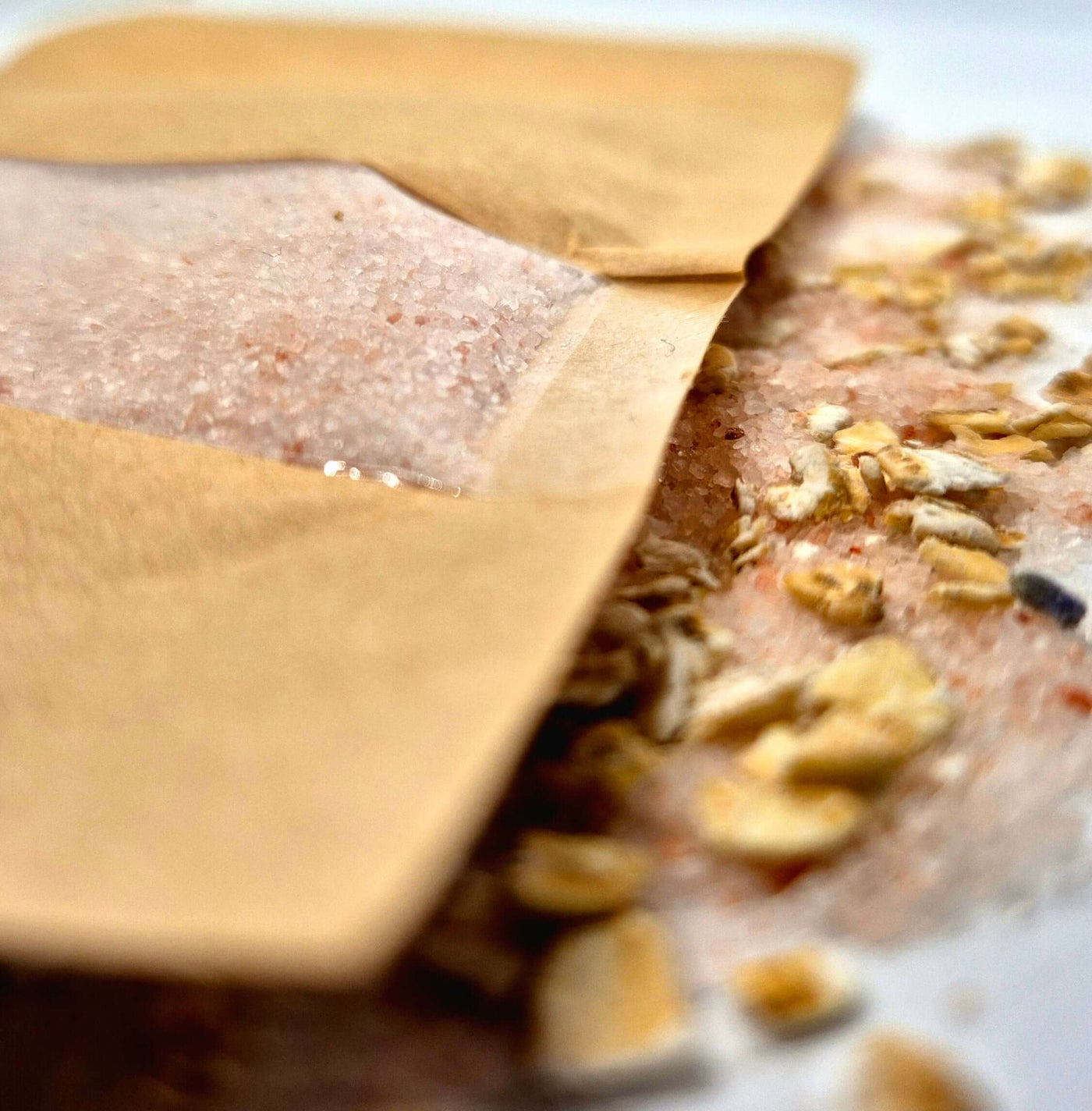 Oat bath salts package with mineral-rich salts and oats spilled, perfect for a soothing bath experience.