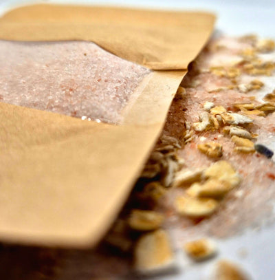 Oat bath salts package with mineral-rich salts and oats spilled, perfect for a soothing bath experience.