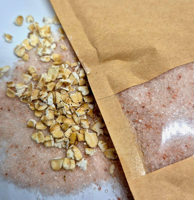 Oat bath salts in a bag with oat flakes, showcasing a relaxing bath experience and skin-soothing ingredients.